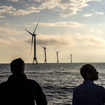 Two people looking at offshore windmills in New England