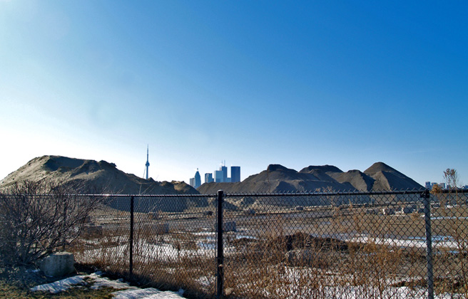 A view of a fenced off area where waste is dumped, known as a “brownfield.”