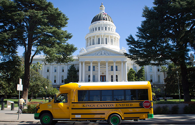 The first all-electric school bus in the state of California pausing outside.