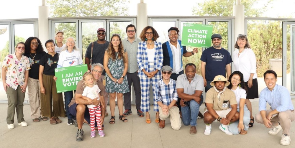 Group of activists posing with Climate Action Now signs