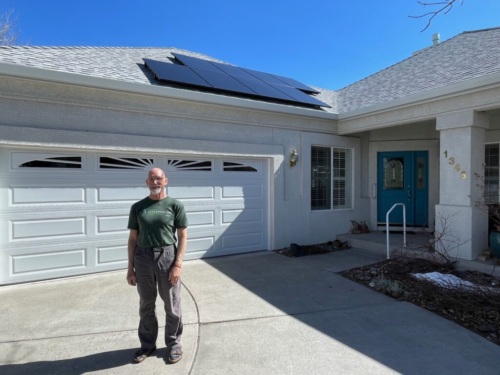 Chas in front of his NV home with solar panels