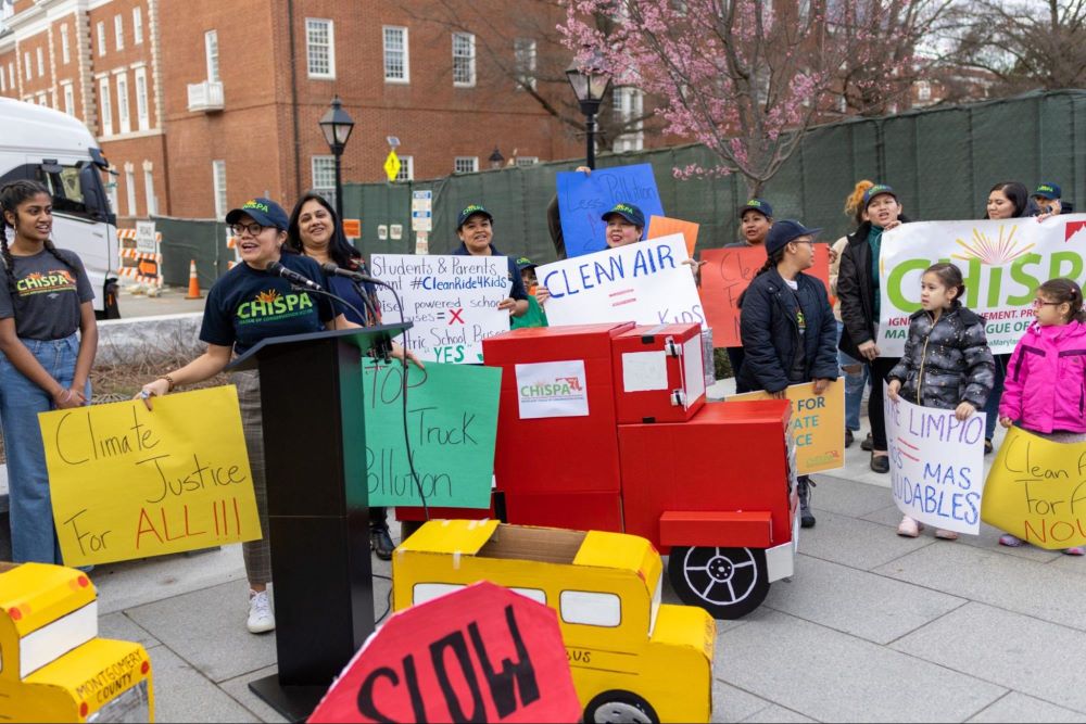 Group of adults and children rallying with Clean Air signs