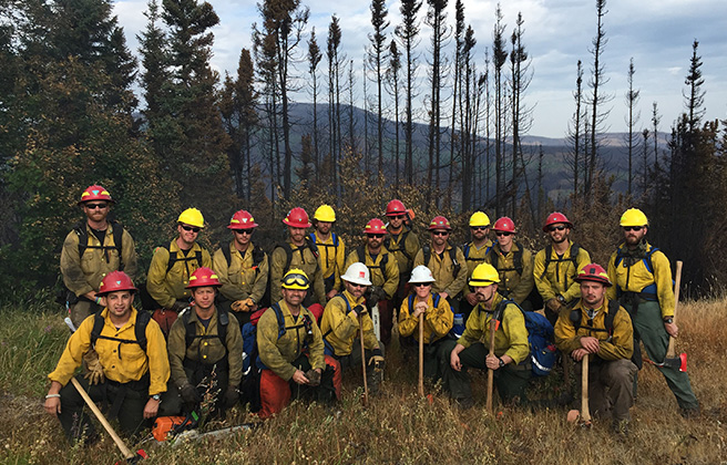 A group of BLM Wyoming workers posing in a group with hard hats on.