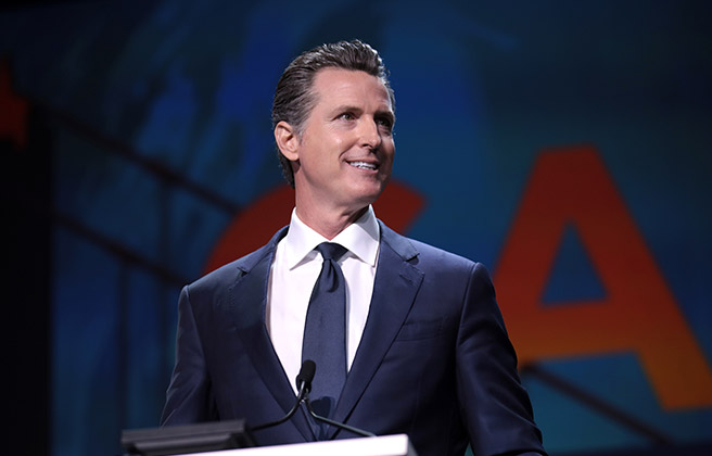 California Governor Gavin Newsome speaks at a podium.