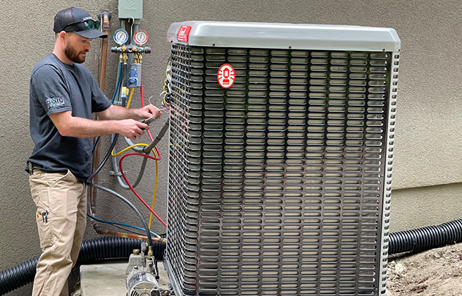 An HVAC technician installing a heat pump at a home.