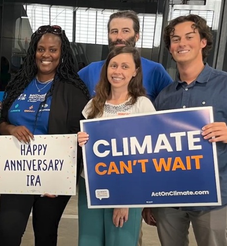 People with Climate Can't Wait signs celebrating the one year anniversary of the Inflation Reduction Act