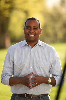 Portrait of Representative Joe Neguse standing outside.