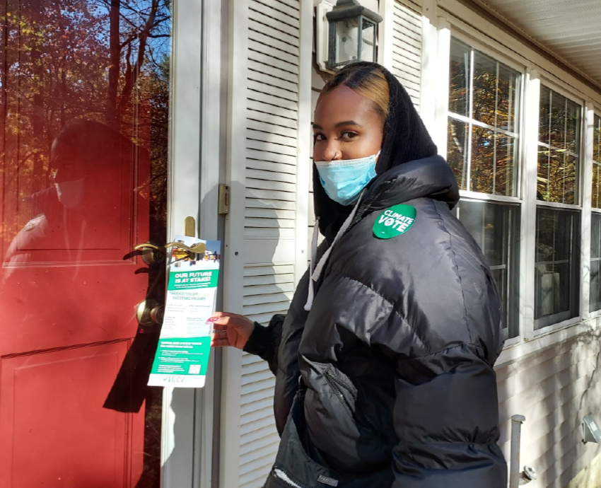 LCV volunteer going door to door putting "leave behinds" on doors.