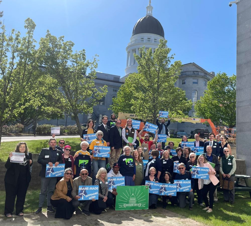 Activists posing with "Maine Made Offshore Winds" posters