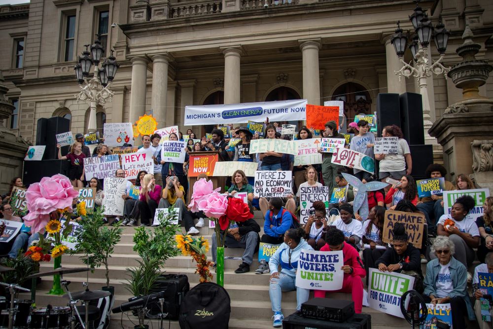 Group of activists posting with Clean Energy signs