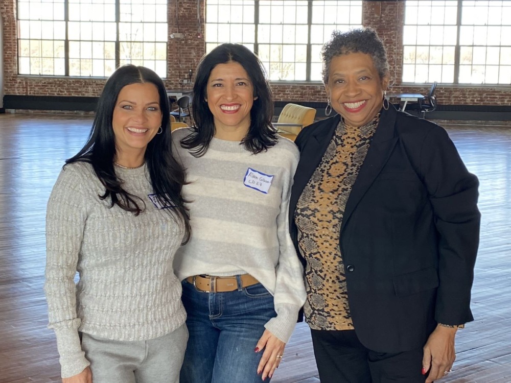 Three women pose together.