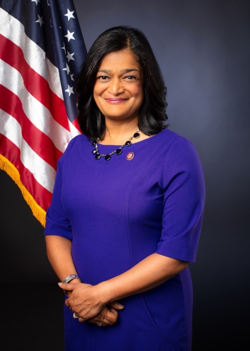 Representative Pramila Jayapal poses by an American flag.