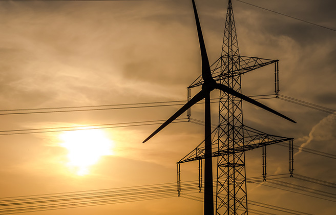 A wind turbine in front of an electric power line.