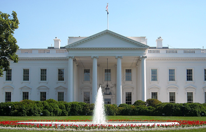 A view of the White House facade with a fountain in the foreground.